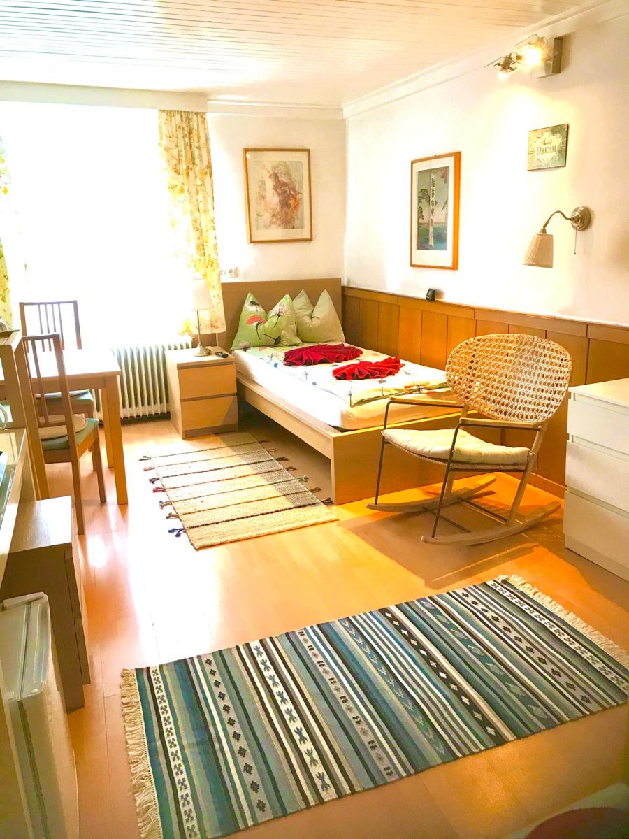 Zimmer im Haus Feuchtl – zwei gerahmte Arbeiten aus der Feuchtl Collection hängen über dem Bett an der weißen Wand